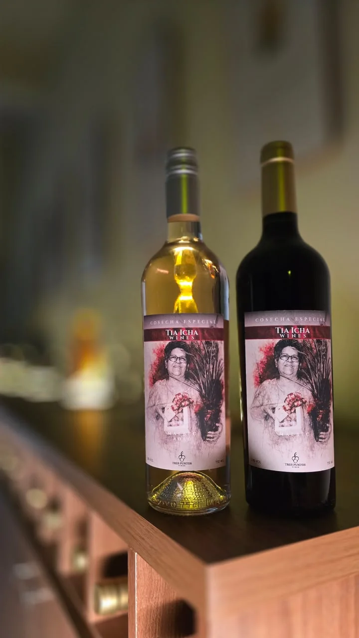 Vino blanco y vino tinto con etiquetas rosadas personalizadas sobre un mostrador