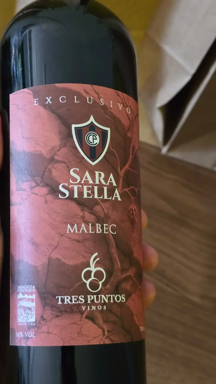 Detalle de etiqueta roja de Malbec personalizada Sara Stella con el logo de Tres Puntos Vinos