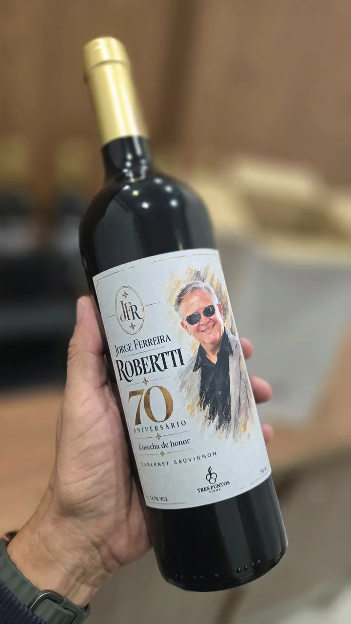 Botella con retrato y etiqueta blanca y dorada para un cumpleaños de setenta años
